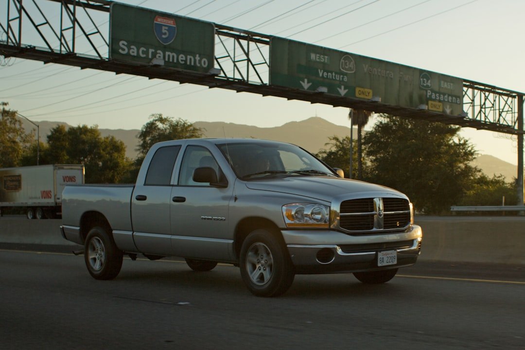 Silver pickup truck driving on highway under sign