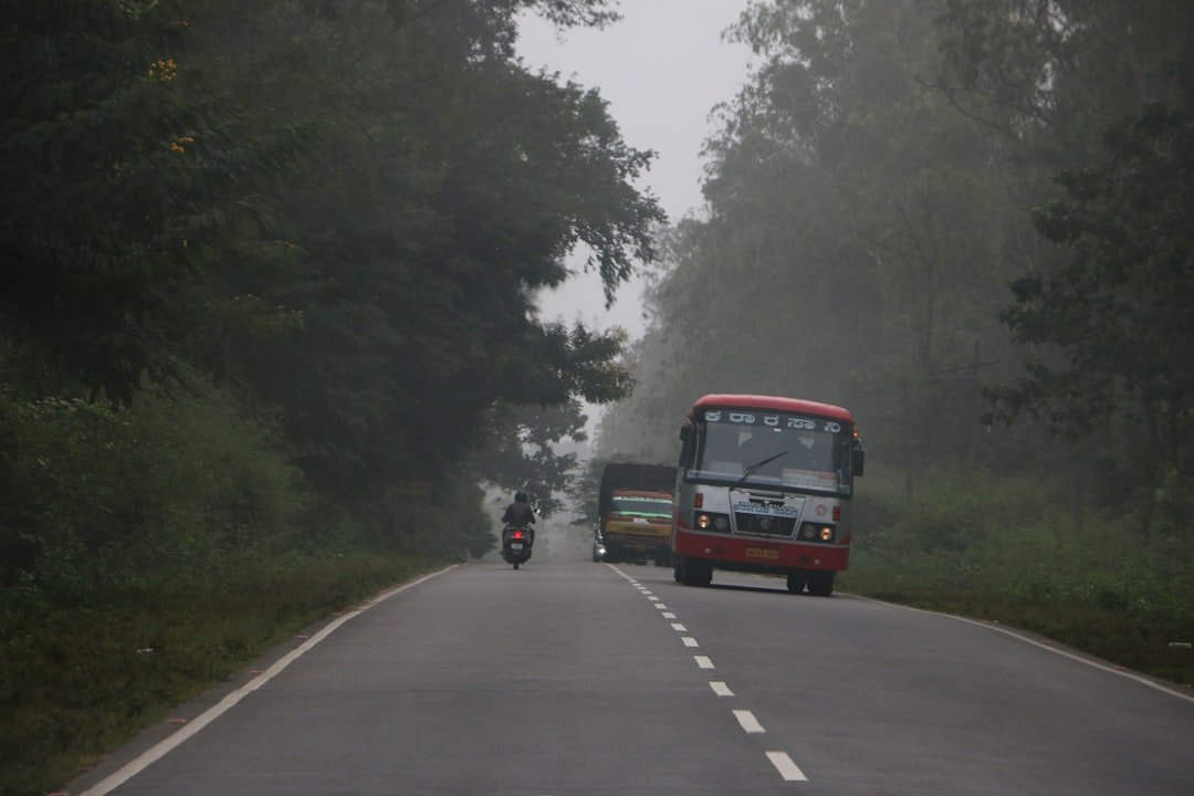 a motorcycle and bus driving down a road