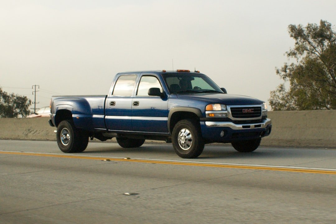 Blue gmc pickup truck driving on a highway.