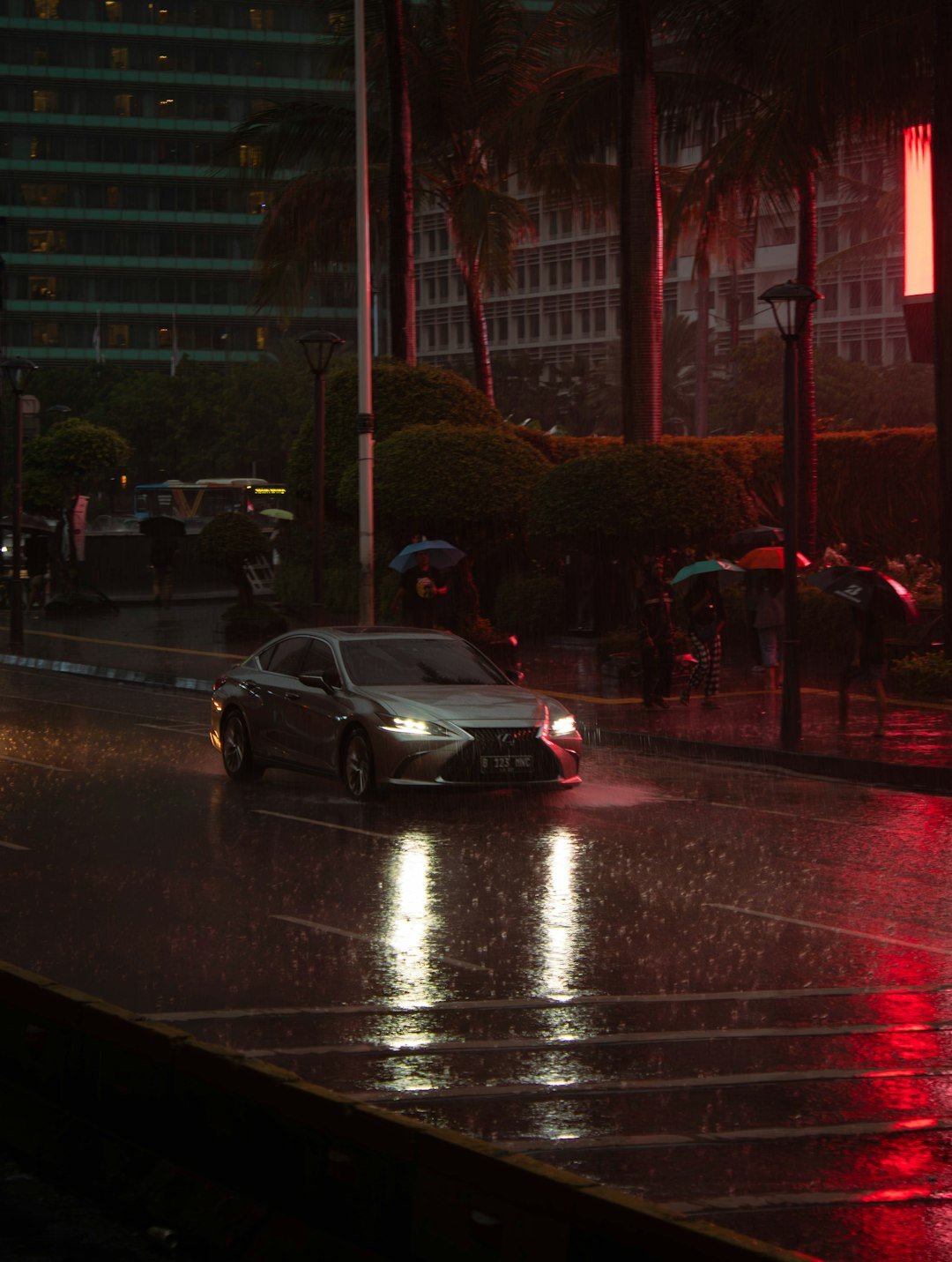 A car drives through a rainy city street.