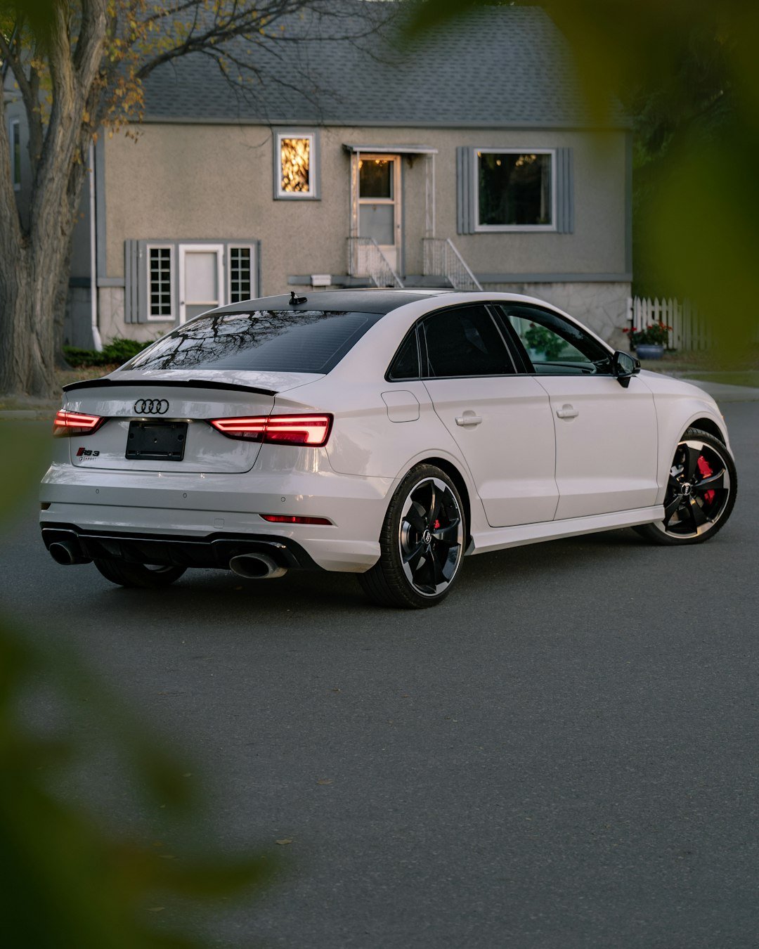 White audi sedan parked in front of a house