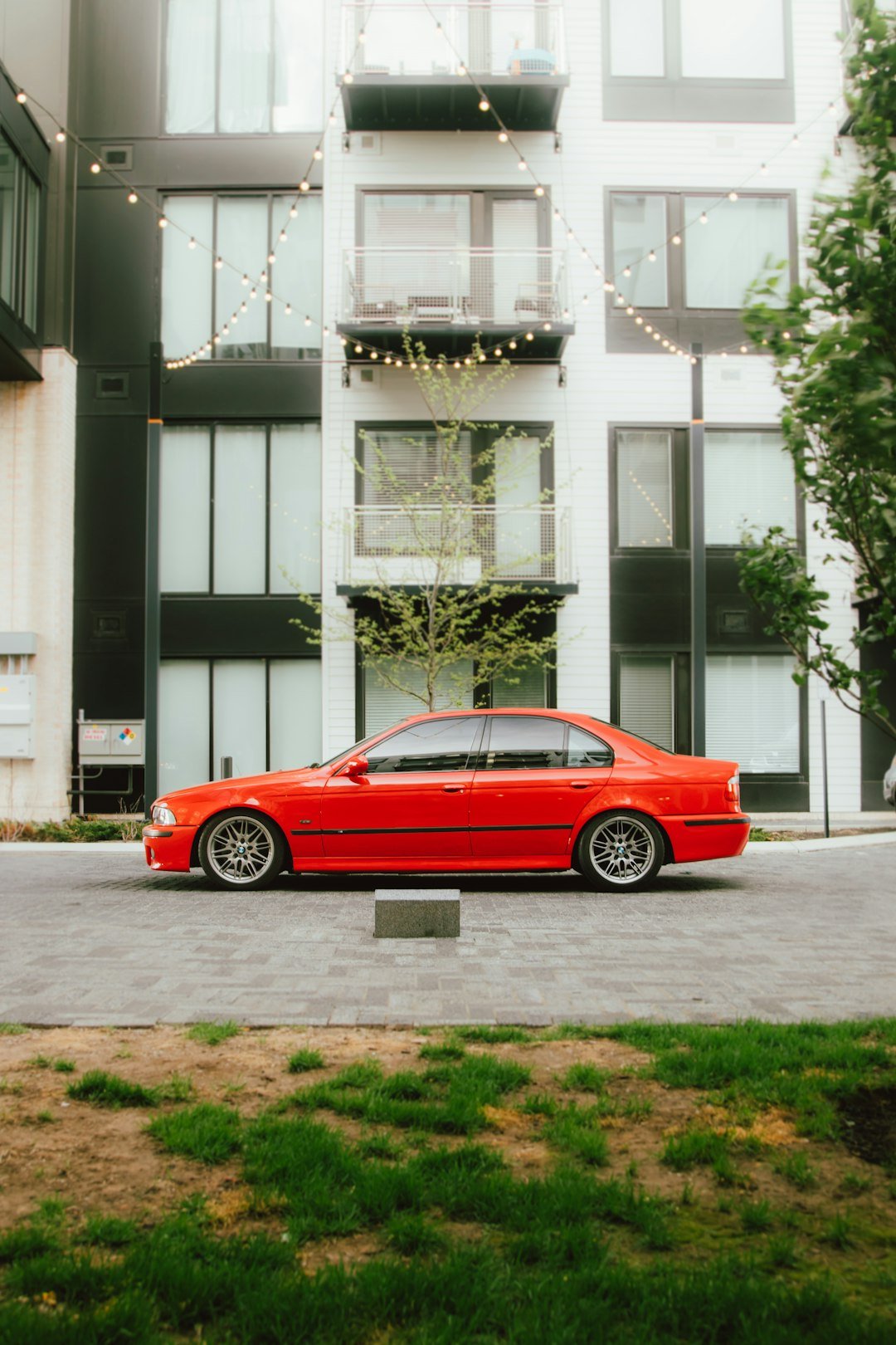 A red sports car is parked in front of a building.