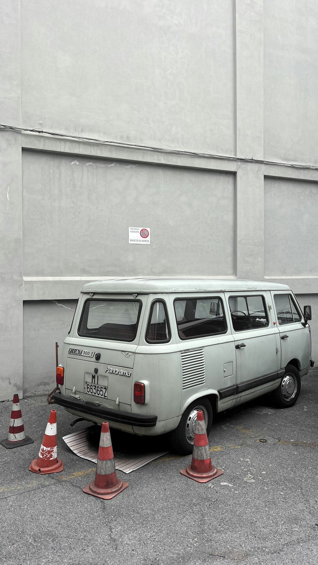 Old van parked with traffic cones.