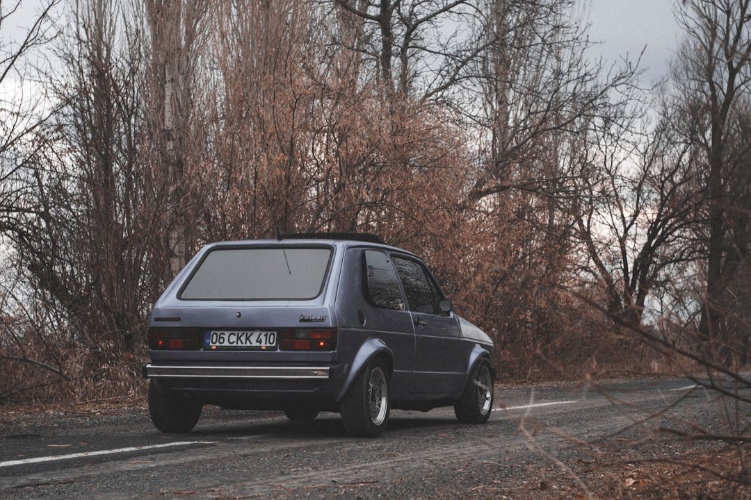 a small car is driving down the road