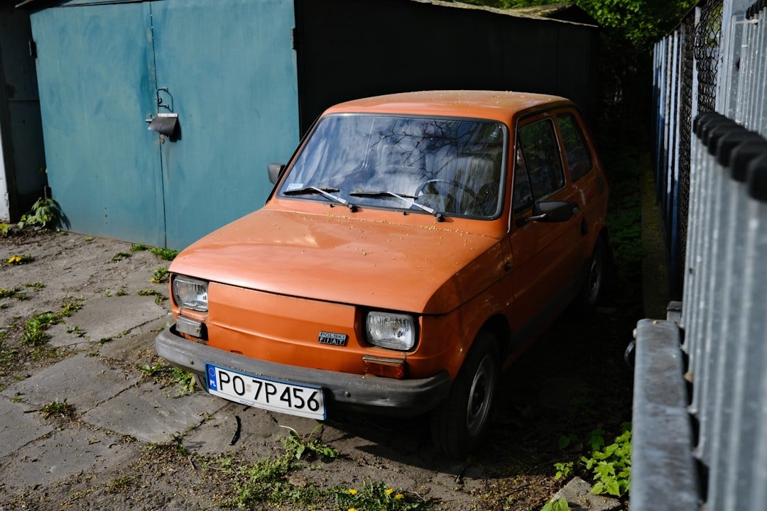an orange car parked next to a building