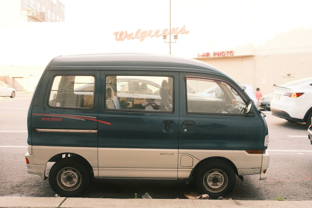 A small van is parked near a walgreens.