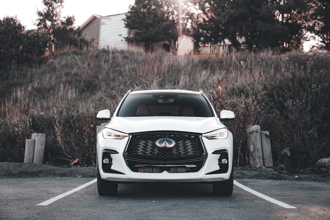 White infiniti suv parked in a lot.
