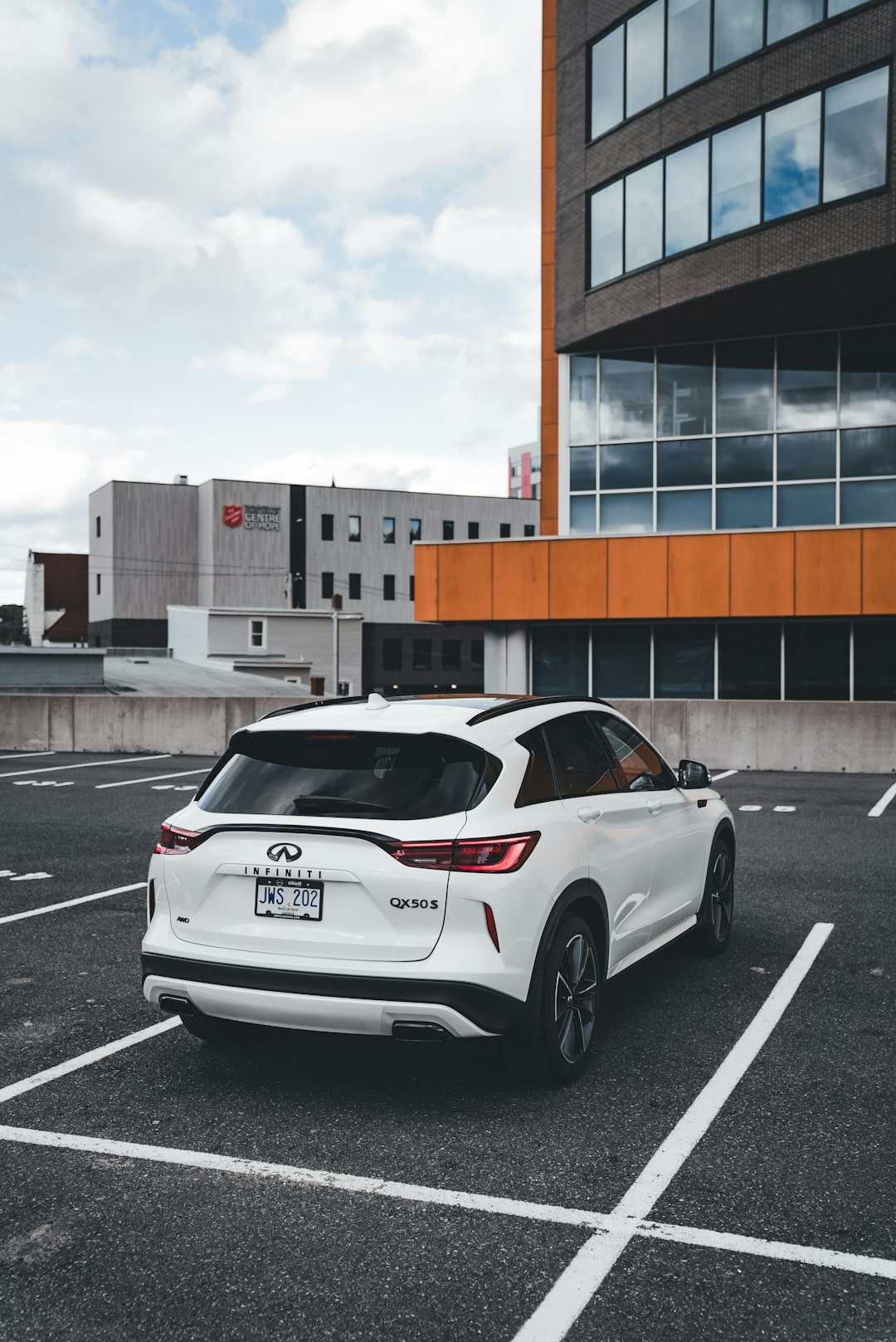 White suv parked in a lot near buildings.
