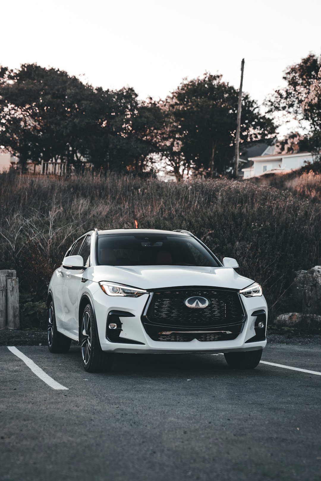 White infiniti suv parked in a lot.