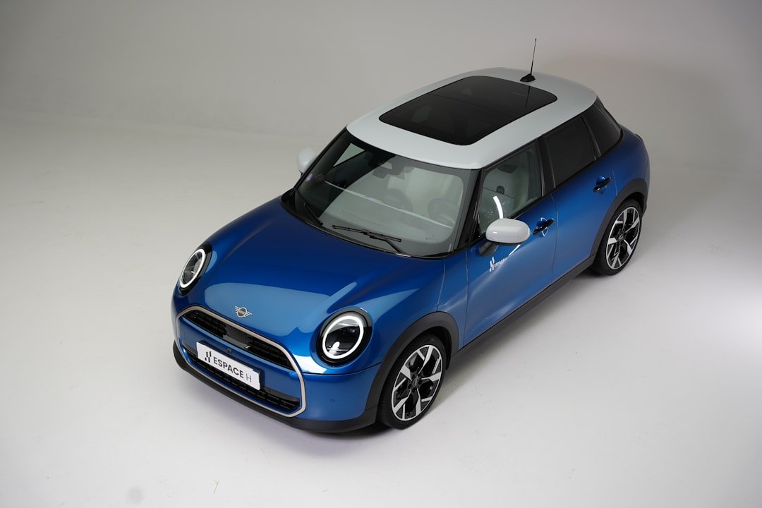 A blue mini cooper with a white roof.