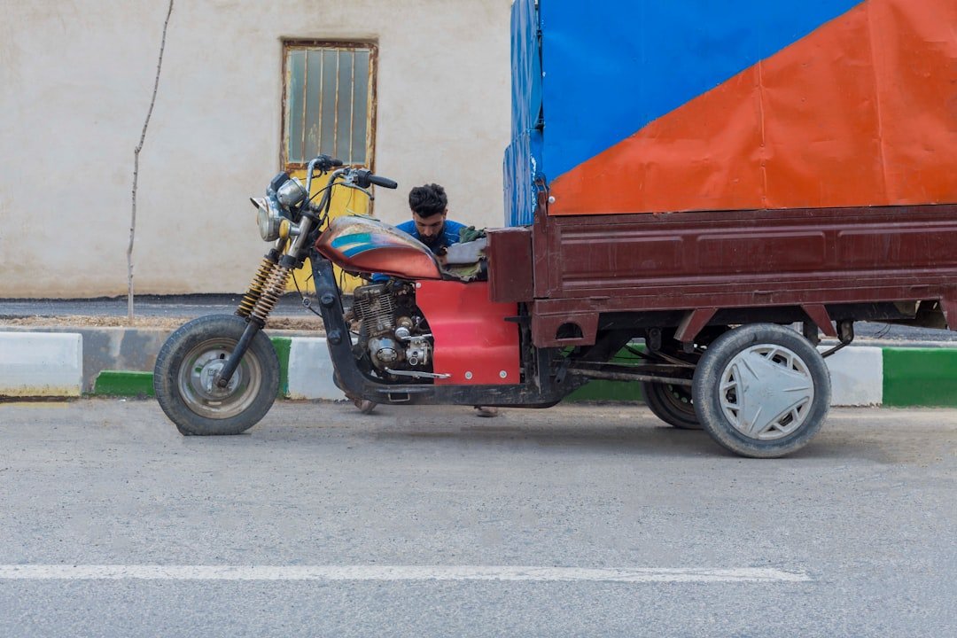 a man riding on the back of a motorcycle next to a truck