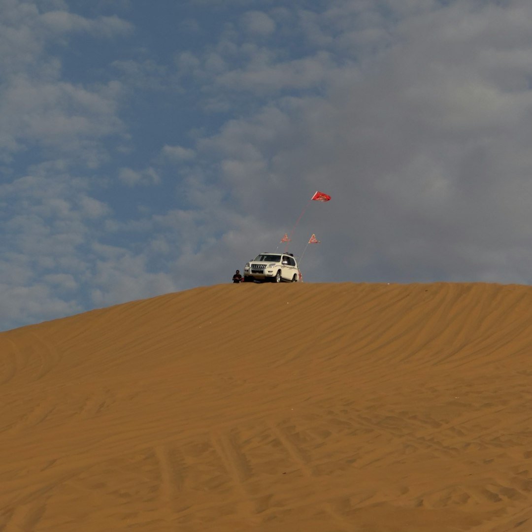 a white truck driving down a sandy hill