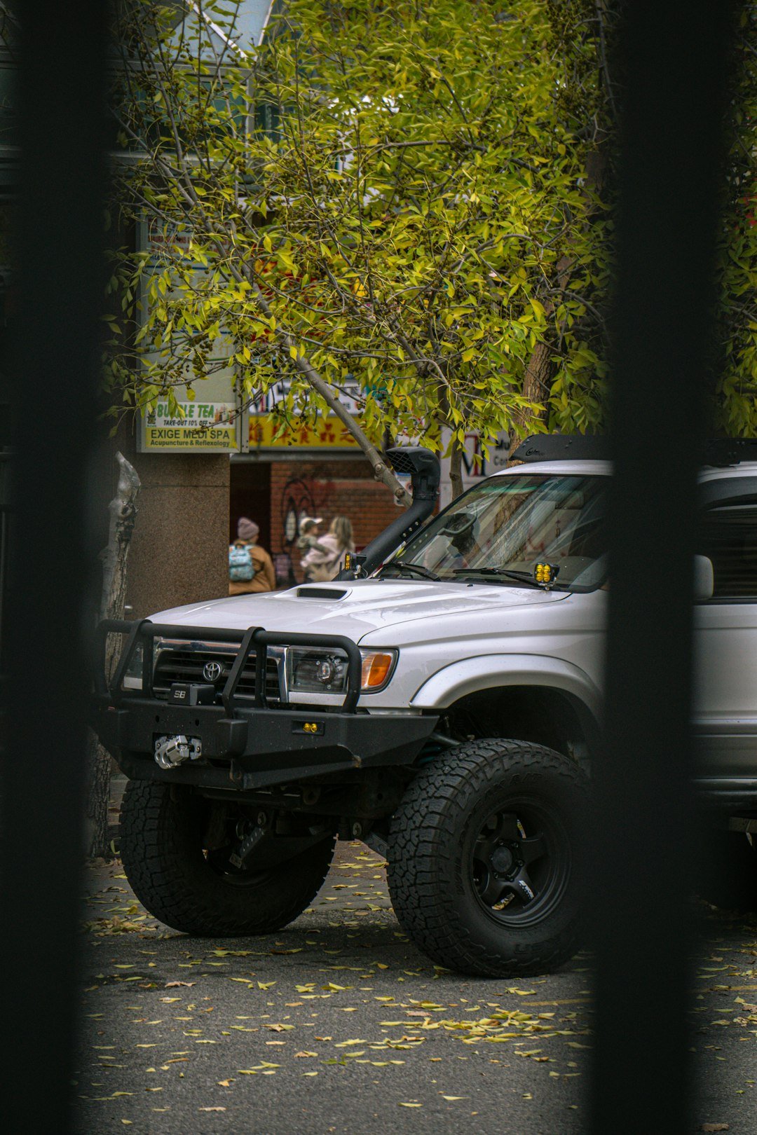 Silver off-road suv parked on a street.
