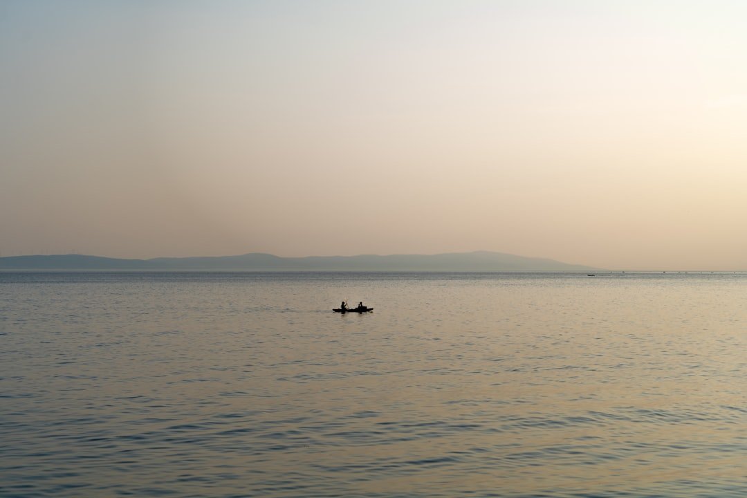 a person in a small boat on a large body of water