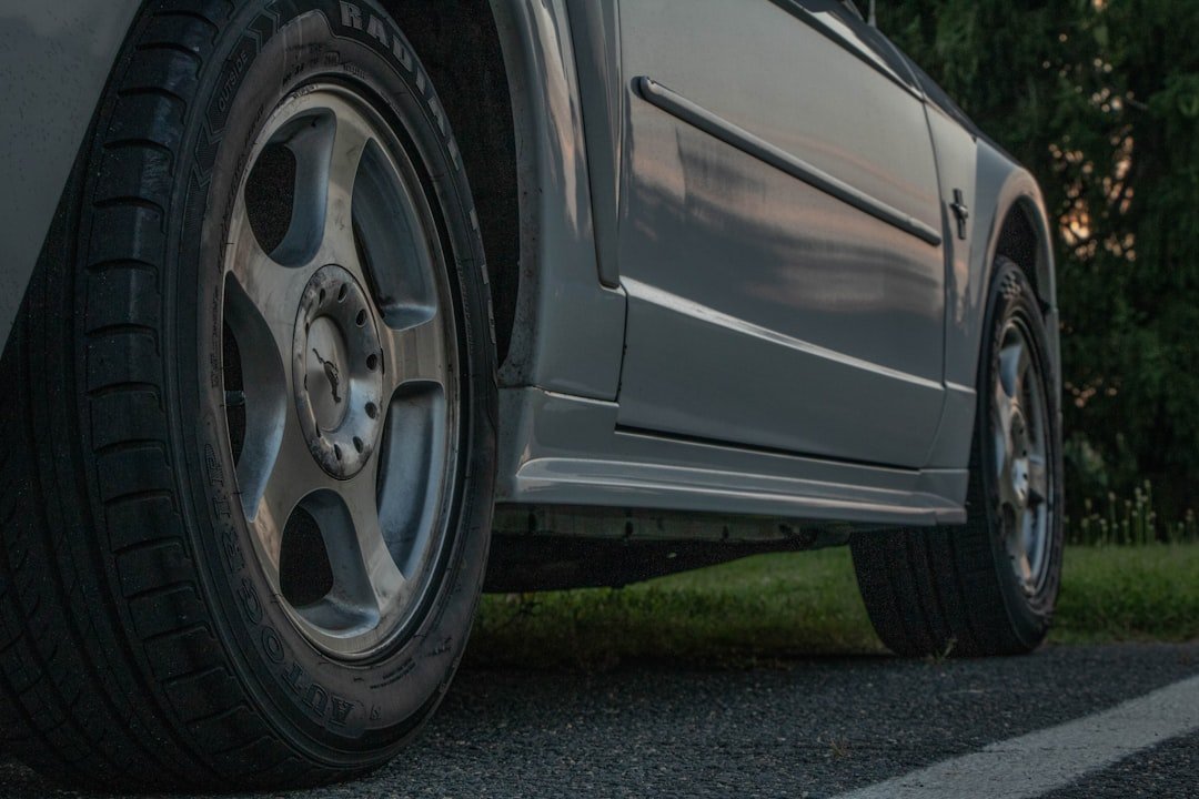 Close-up view of a gray vehicle's wheels and side