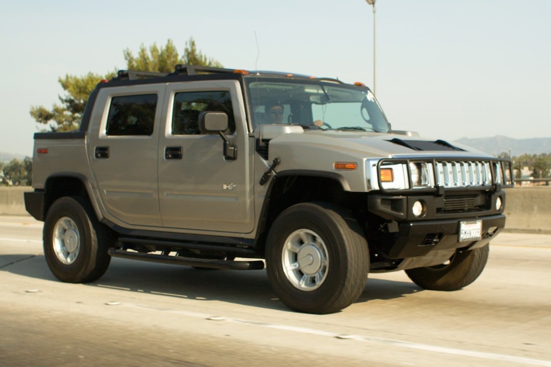 Gray hummer h2 truck driving on a highway.