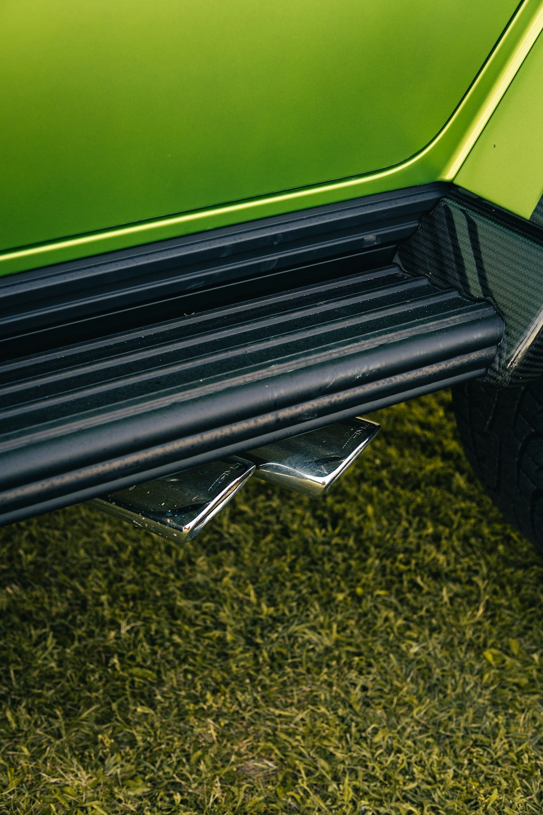 Chrome exhaust pipes on a green vehicle