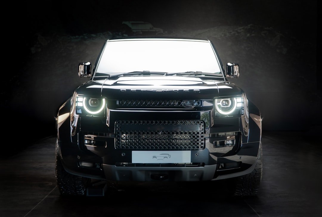 A black land rover defender shines brightly.