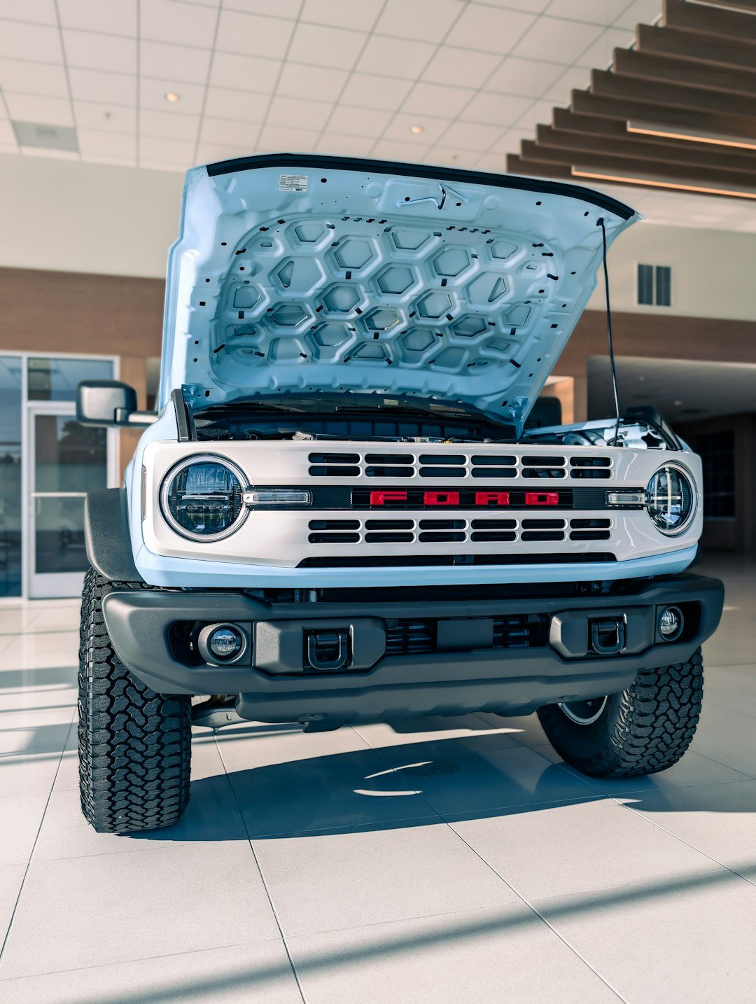 Light blue ford bronco with hood open