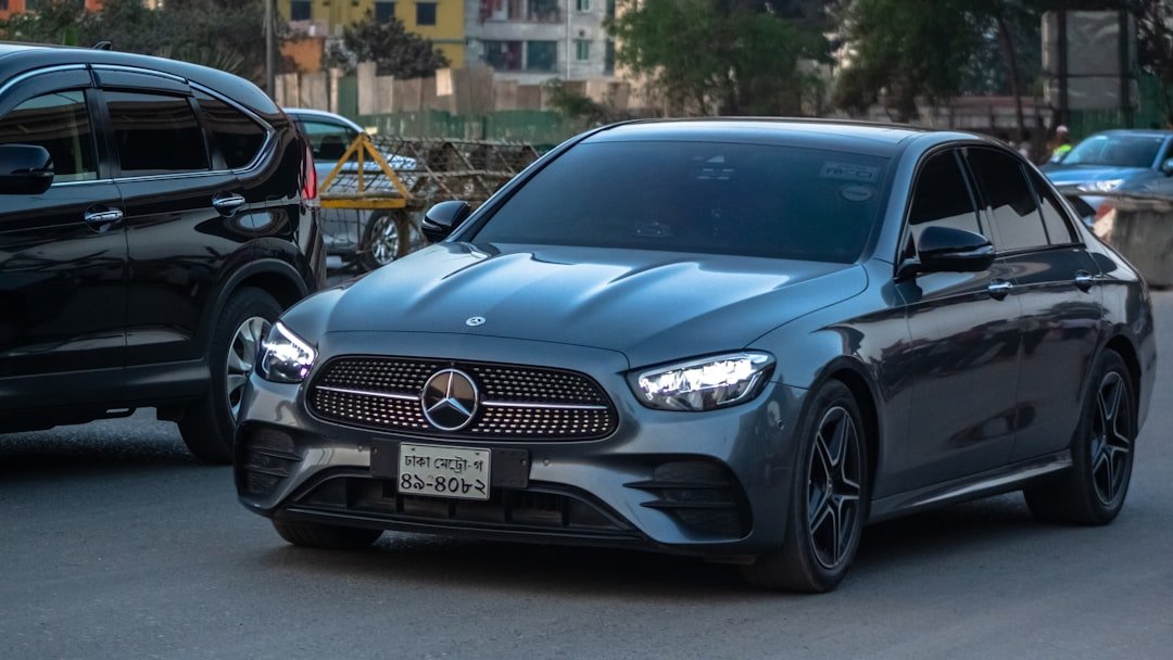 a grey car driving down a street next to a black car
