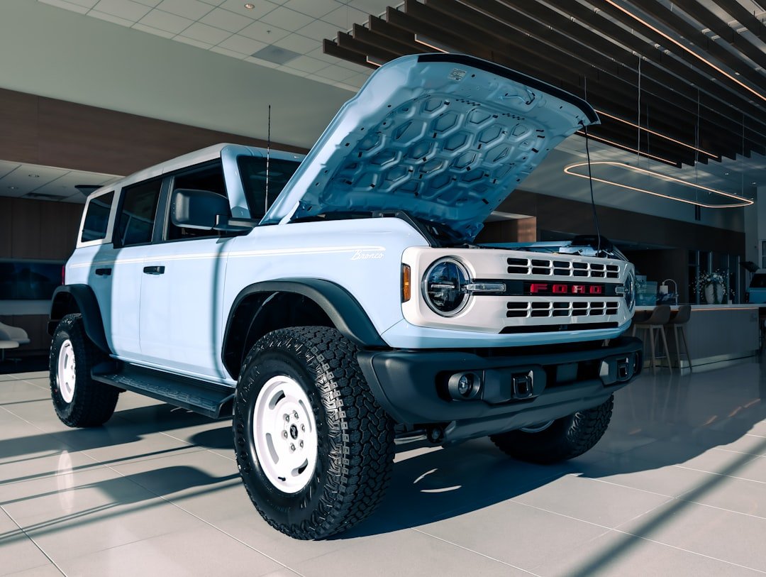 Light blue suv with hood open in showroom