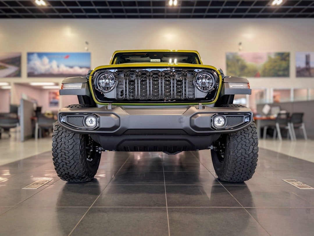 Front view of a yellow jeep wrangler in showroom