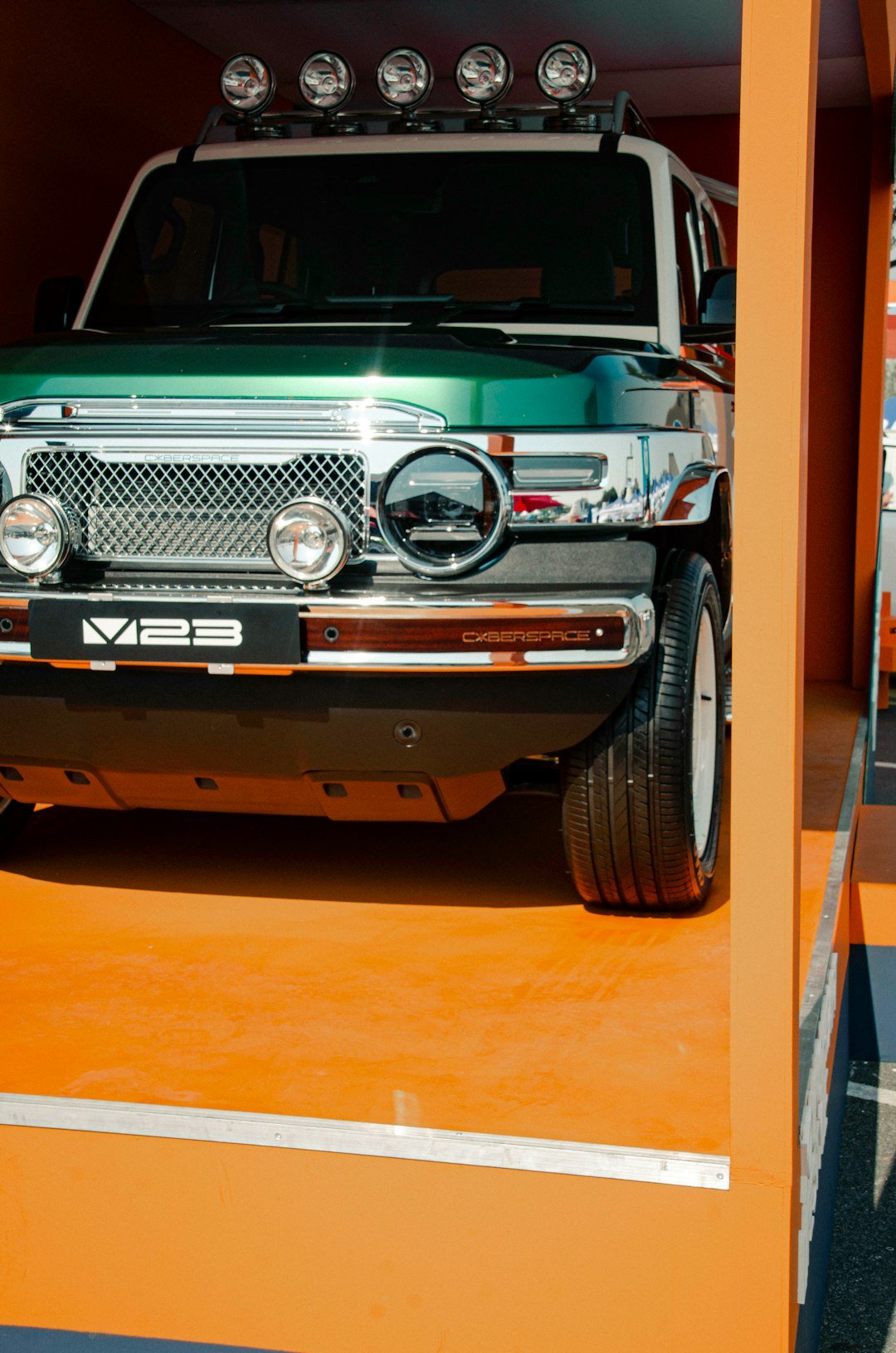 Green and white off-road vehicle with roof lights