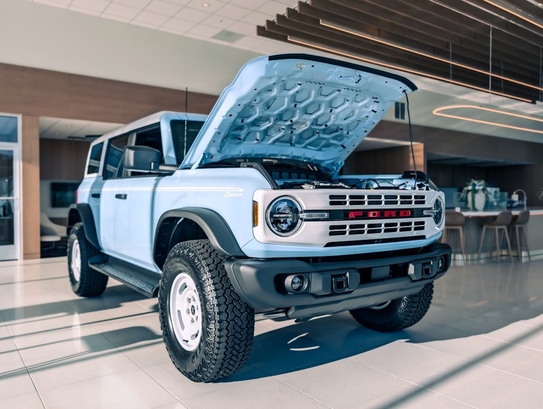 Light blue suv with hood open in showroom.