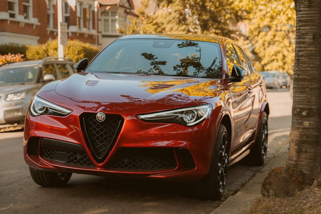 A red alfa romeo suv is parked on the street.