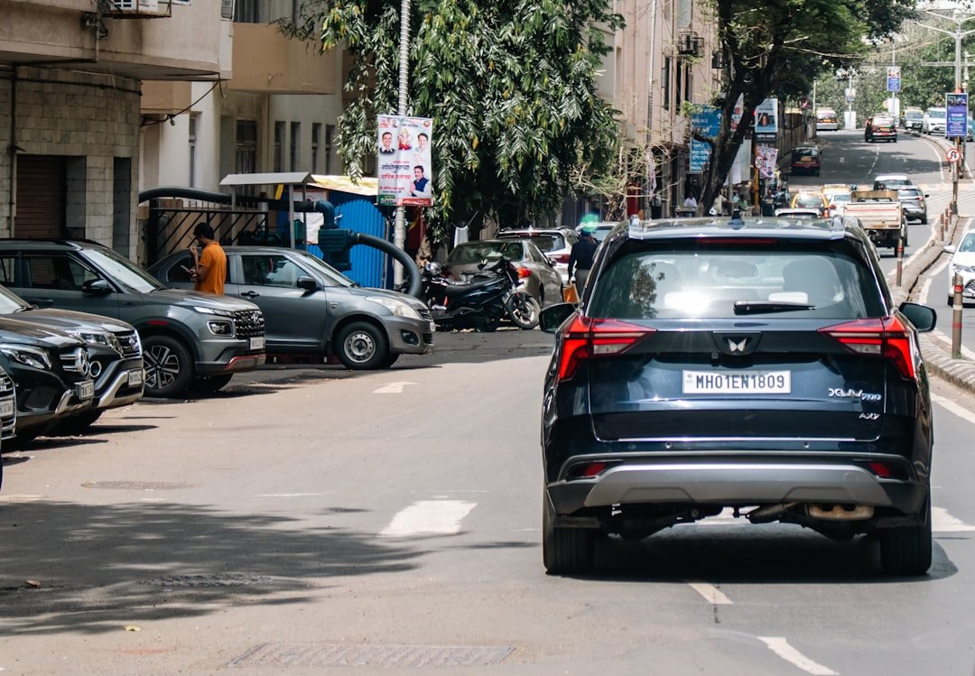 A car driving down a street next to tall buildings