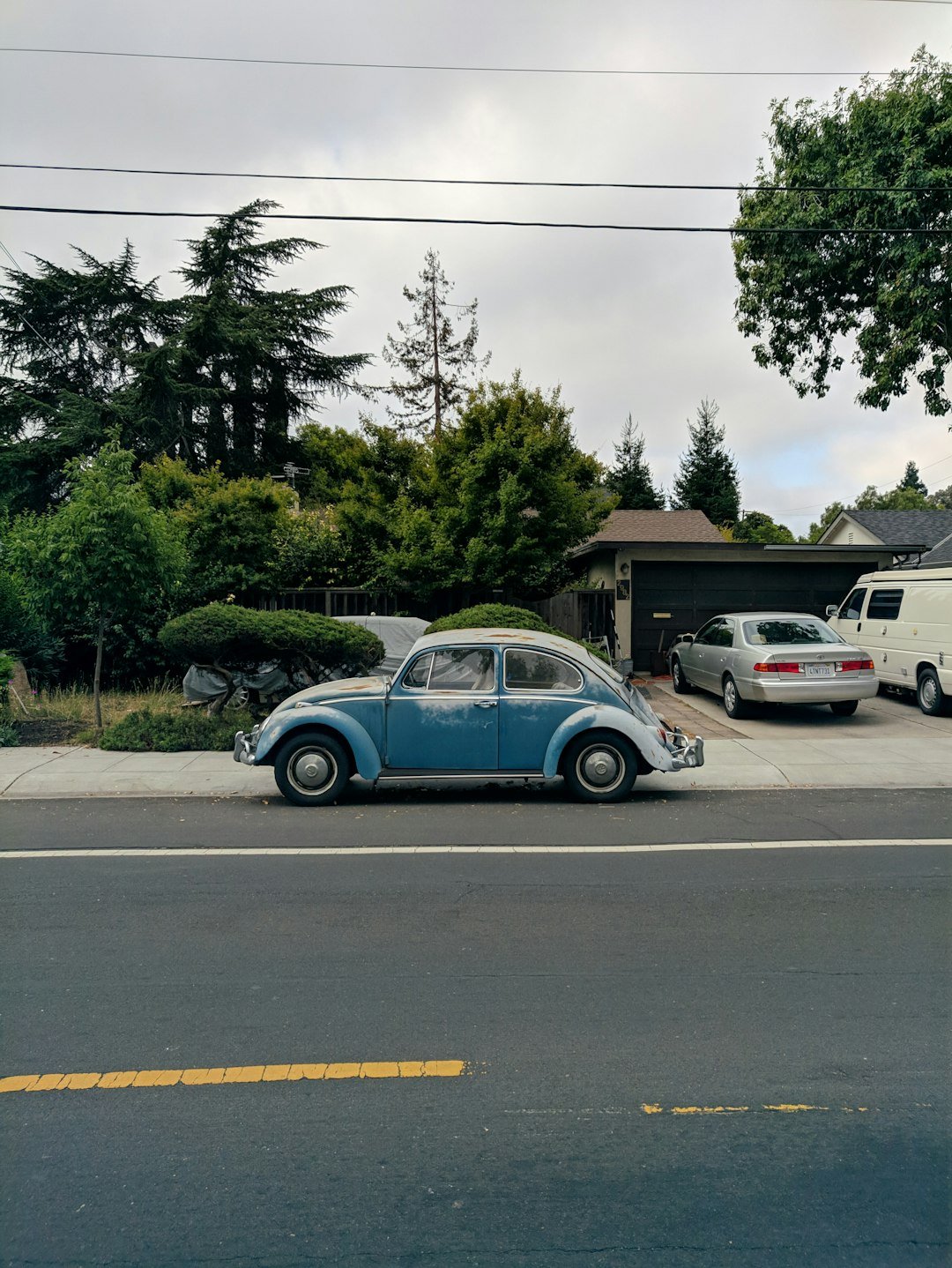blue volkswagen beetle parked on parking lot during daytime