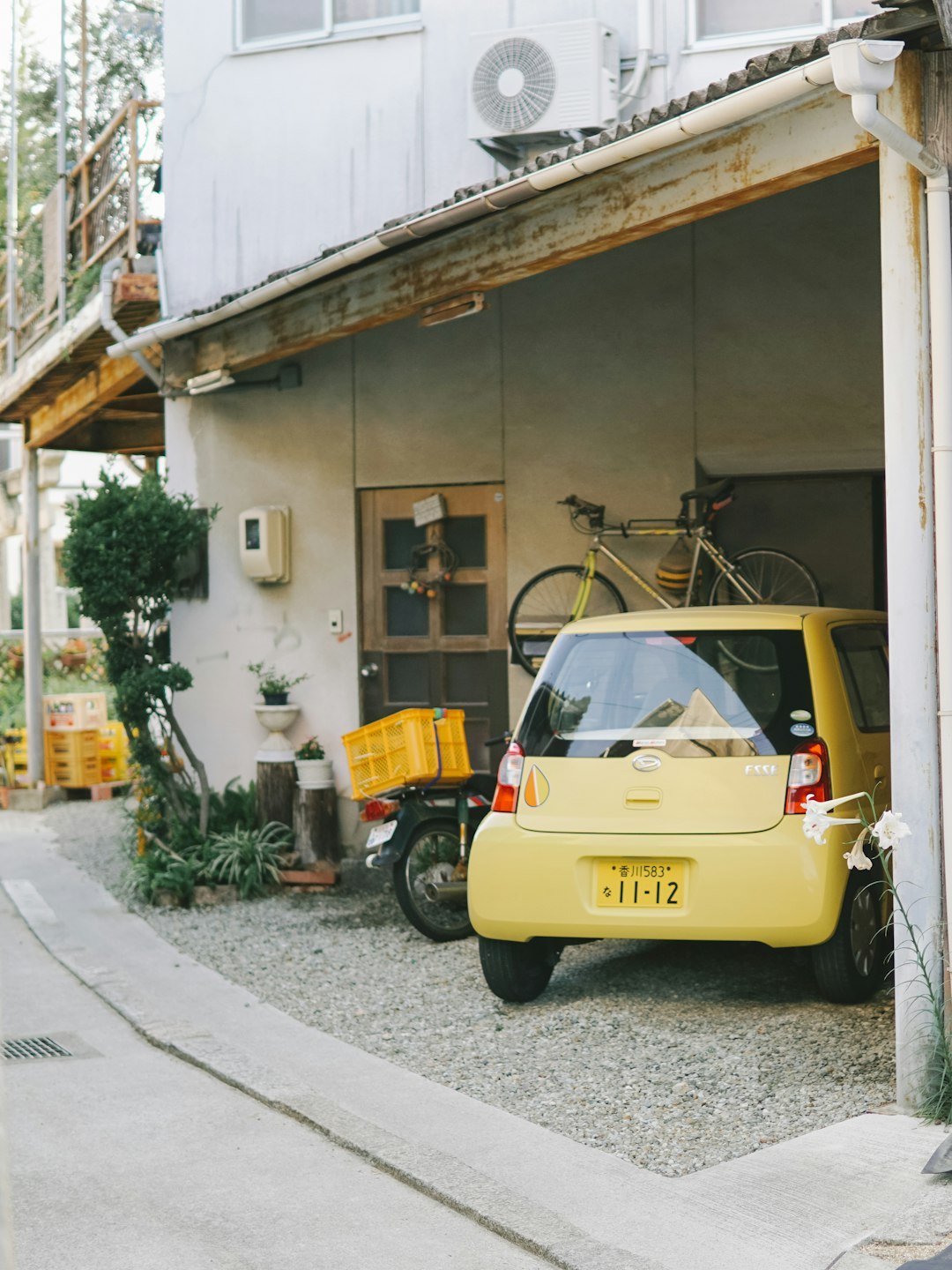 yellow car parked beside white concrete building during daytime