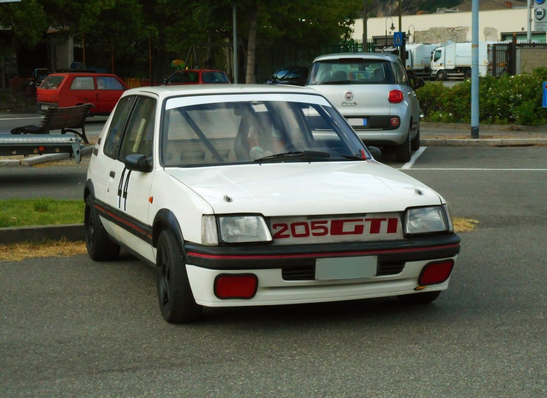 a white car driving down a street next to a park