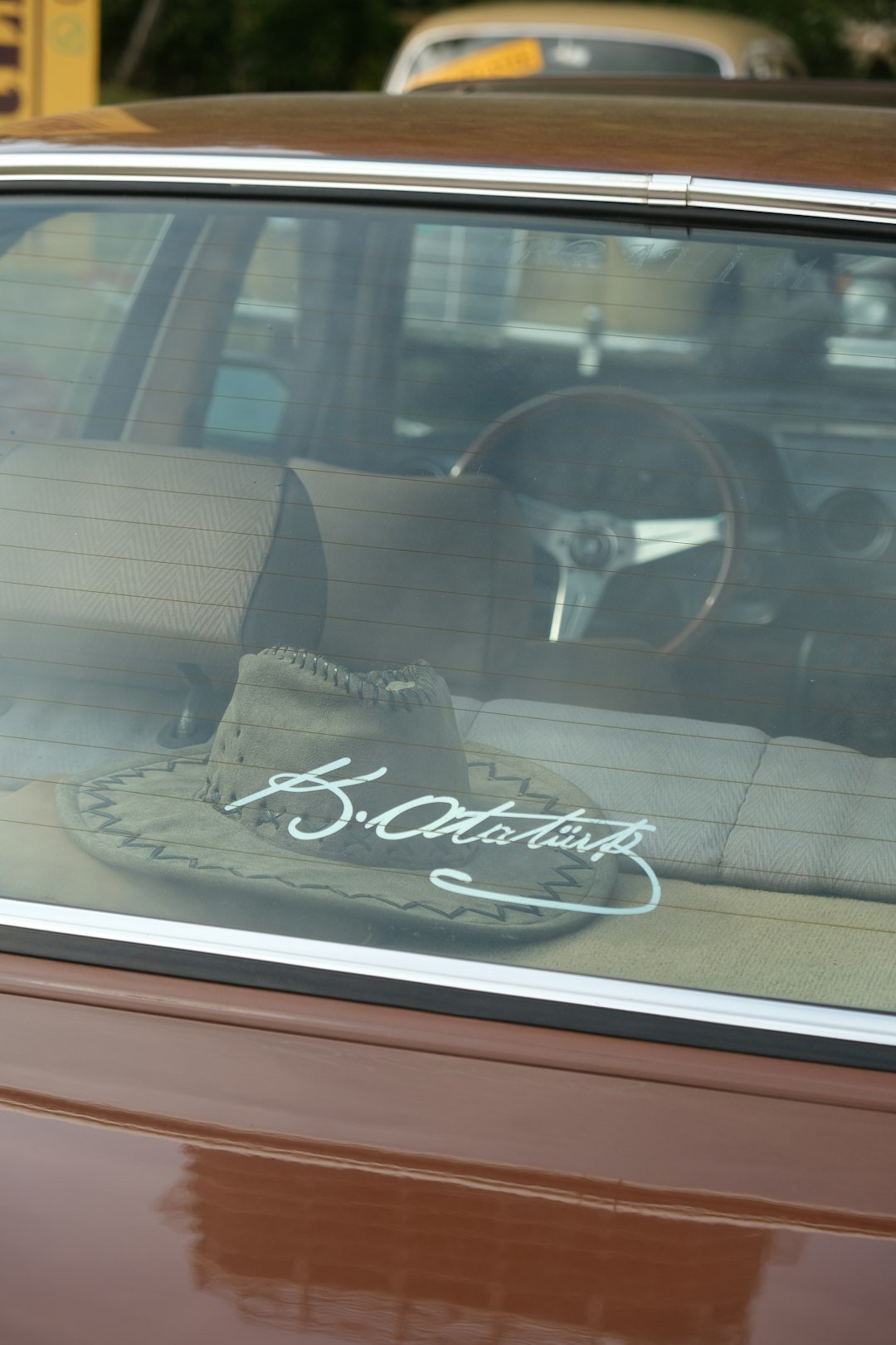 a brown car with a hat on top of it