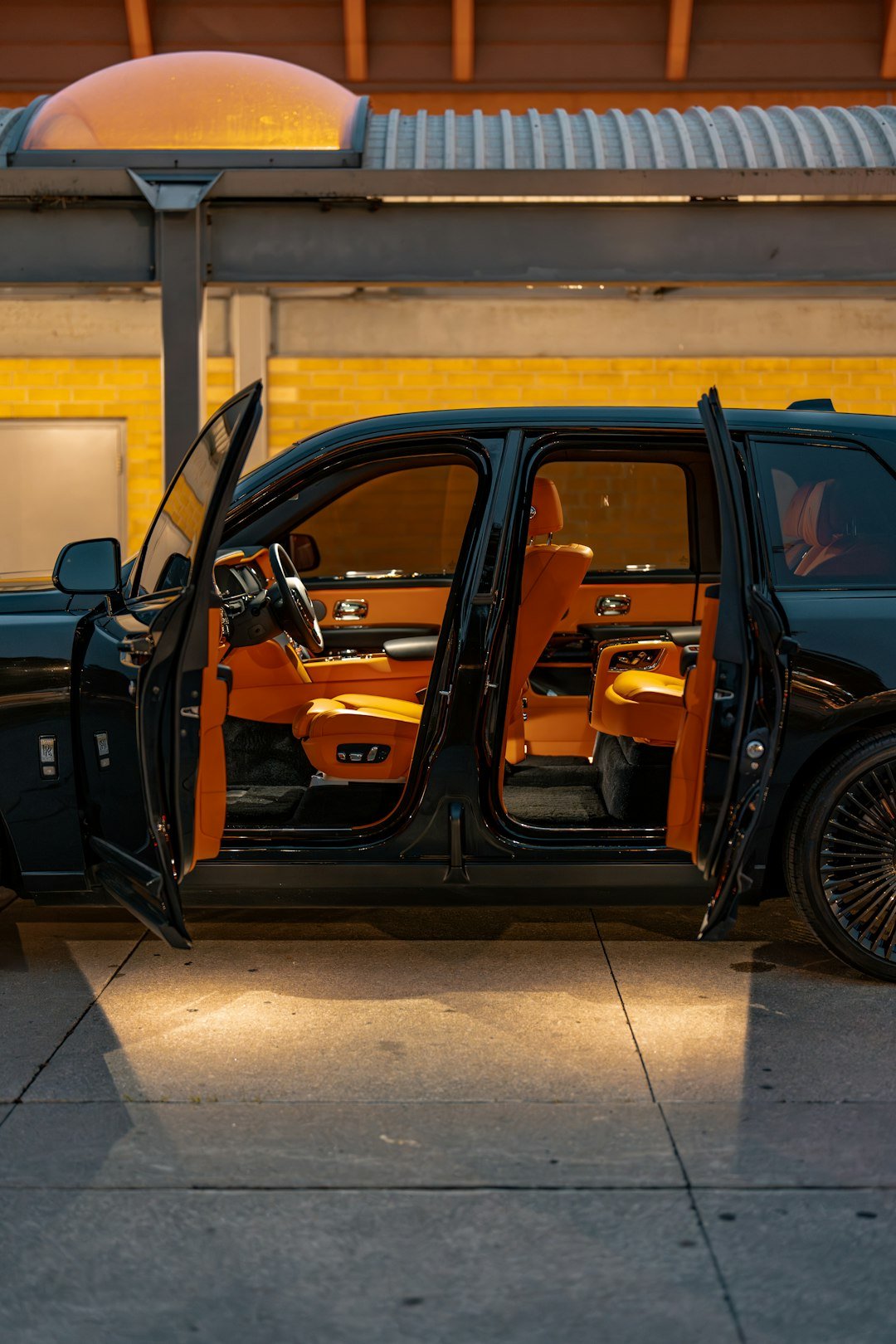 an orange and black car parked in front of a building