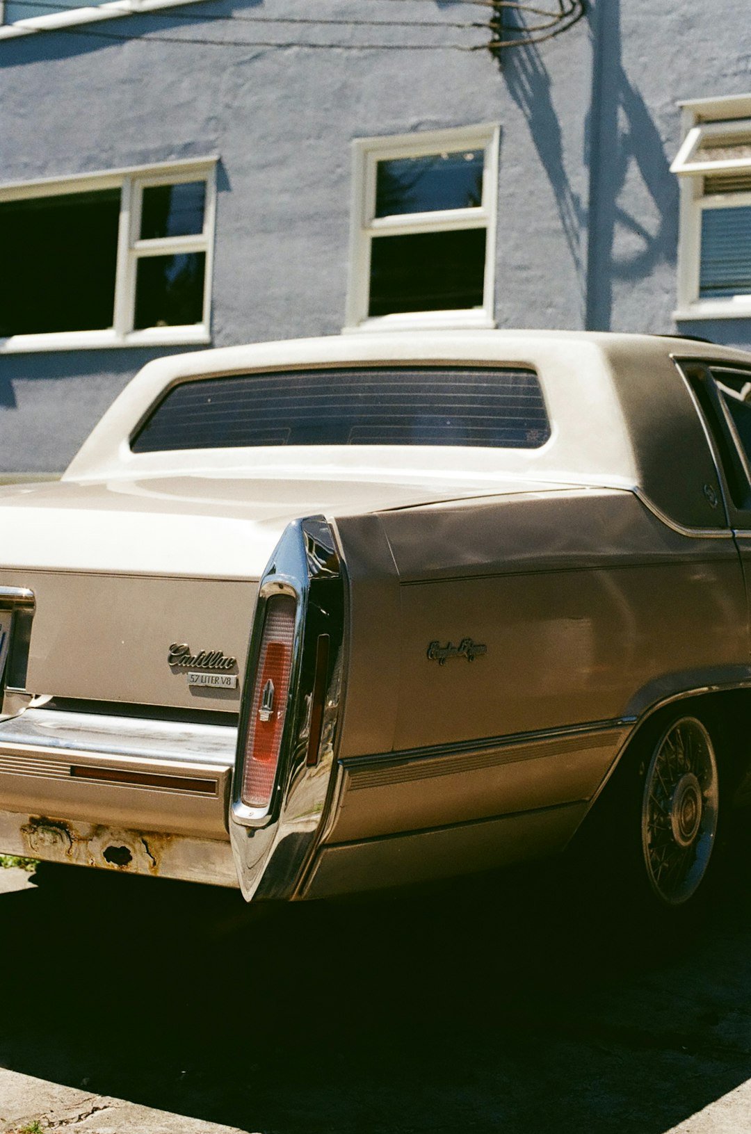 An old car parked in front of a house