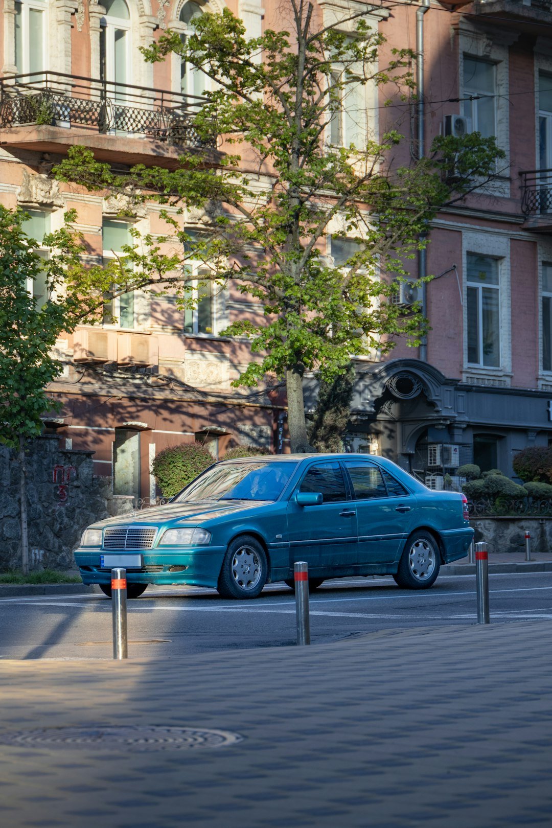 A blue car is parked on a city street.