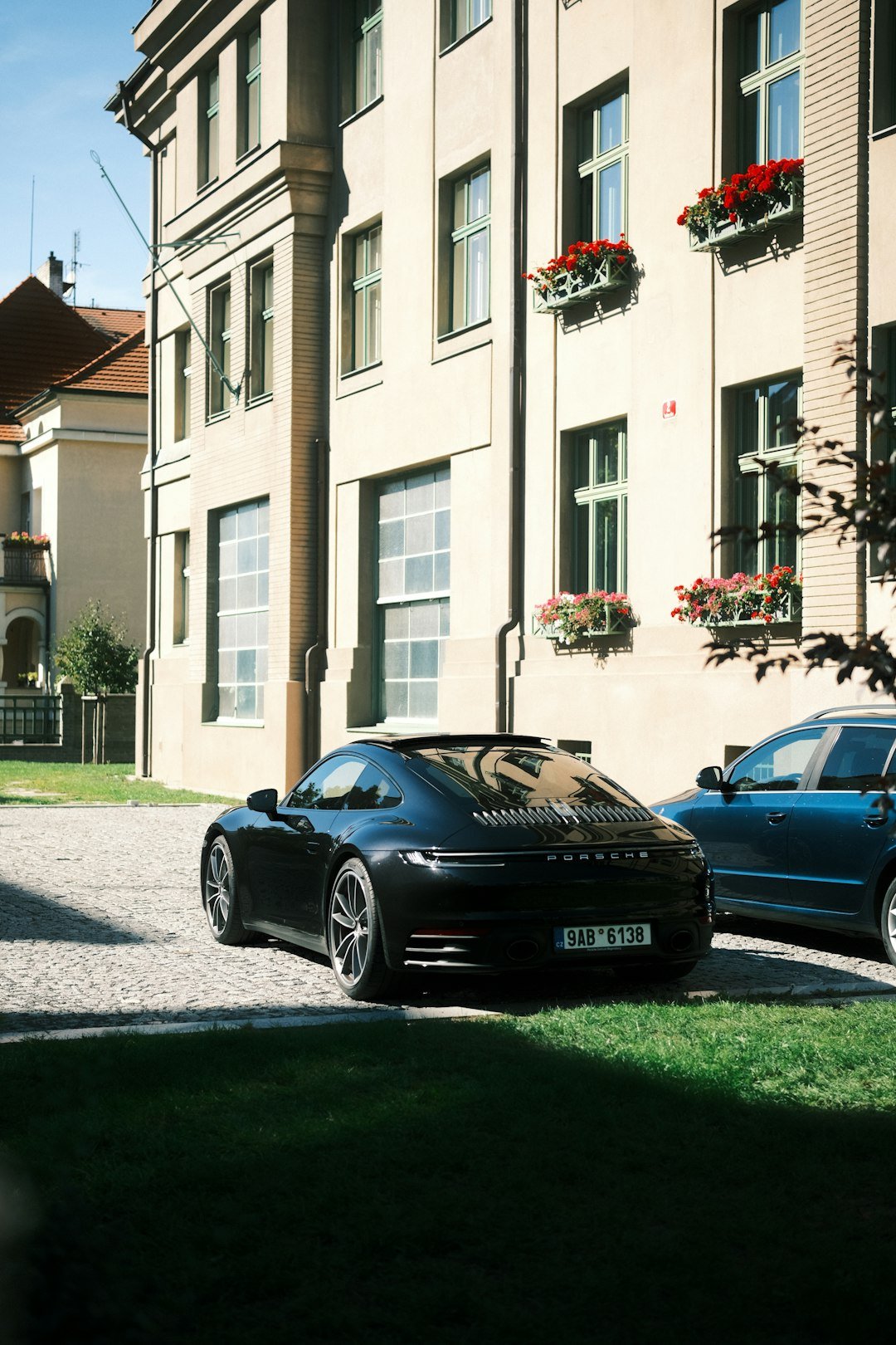 Black porsche parked in front of a building