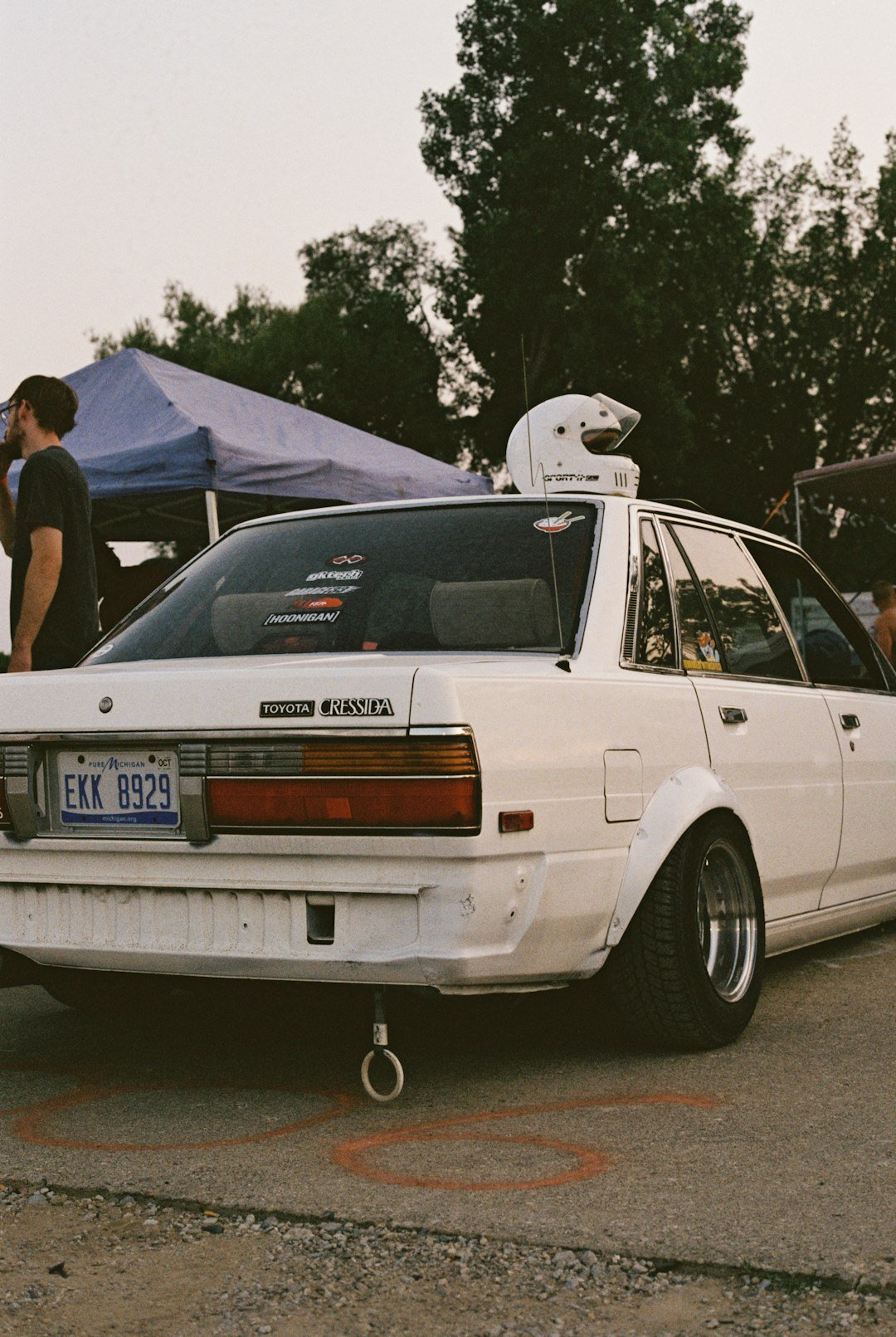 White sedan with racing helmet on roof.