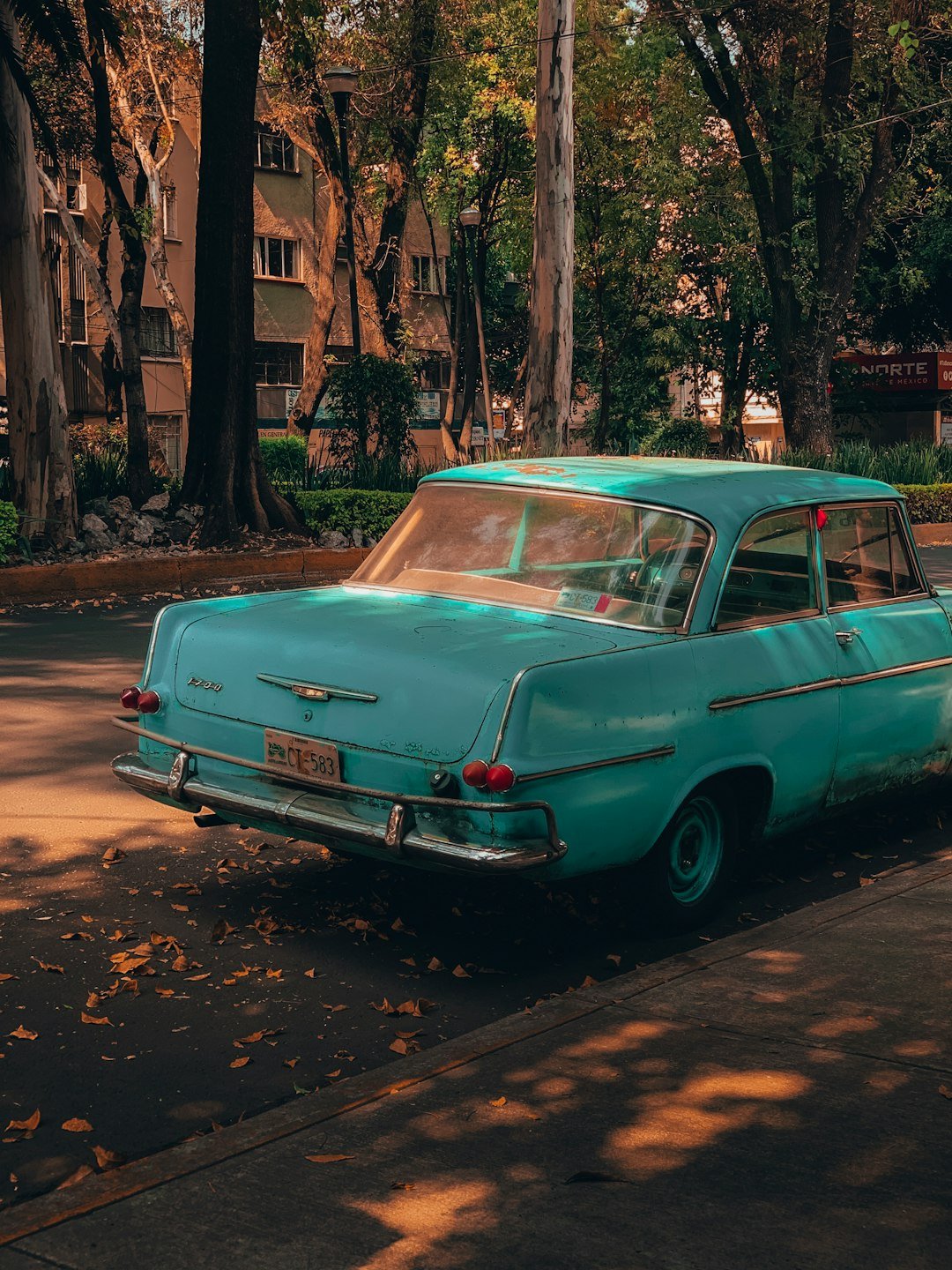 parked teal sedan beside curb