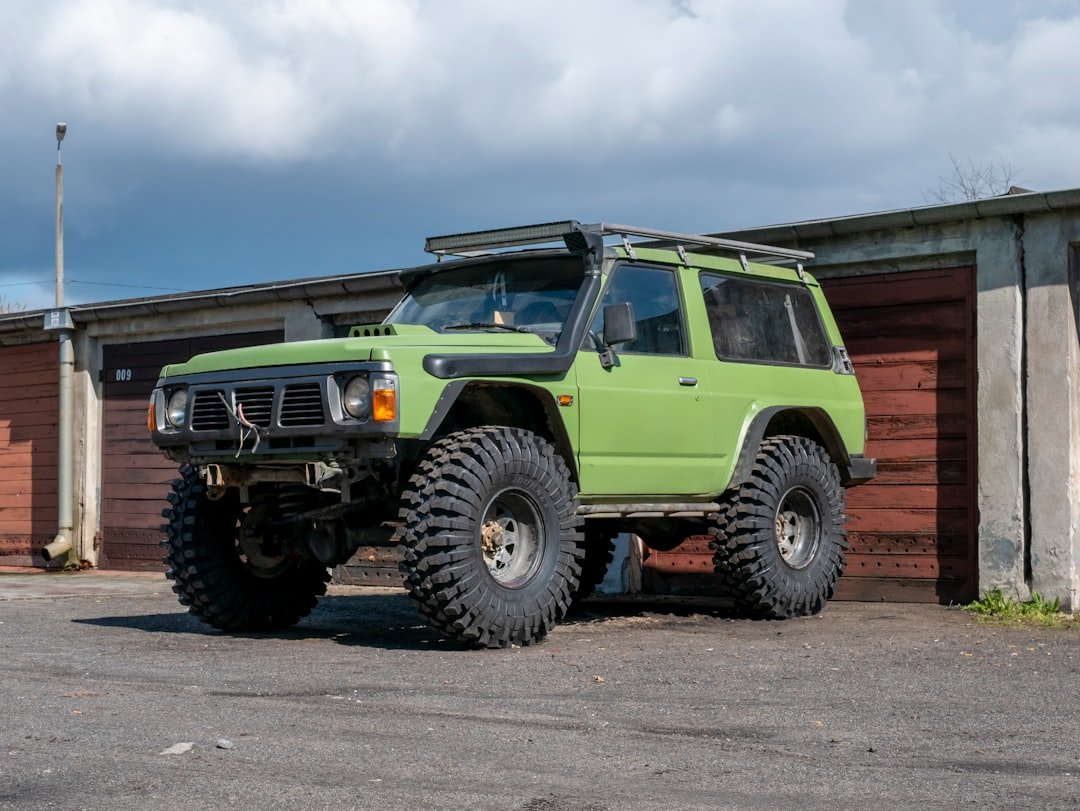 a green jeep parked in front of a building