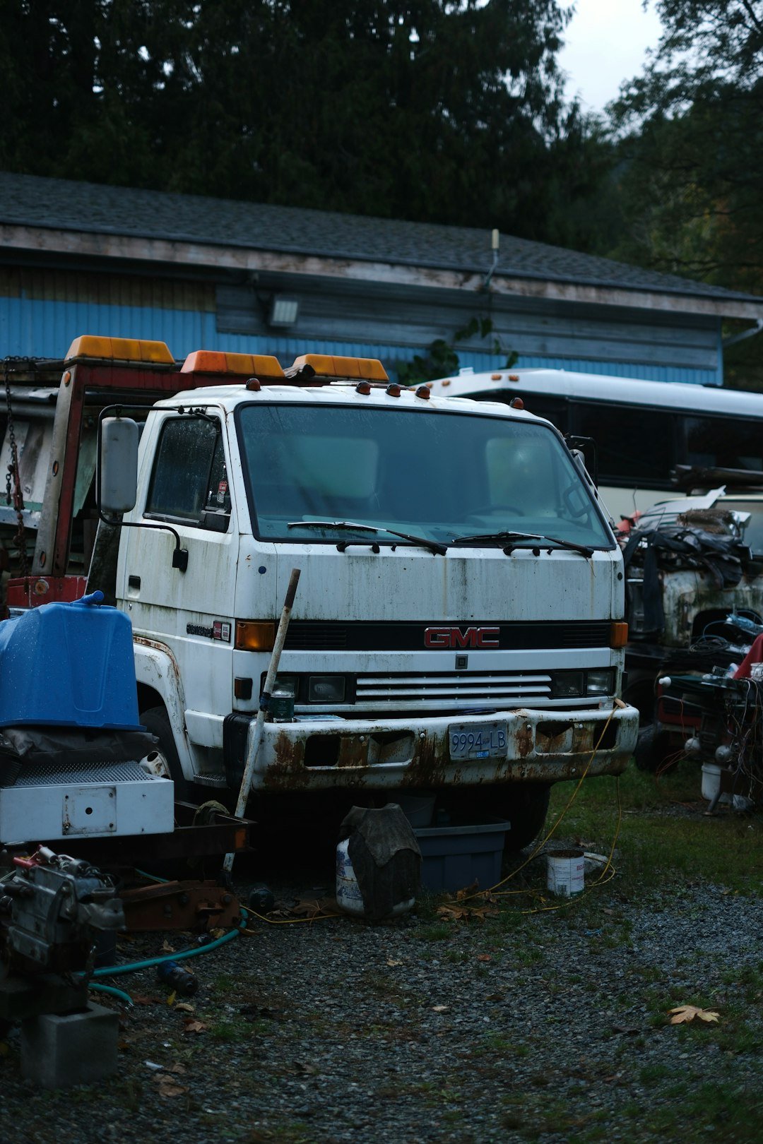 White gmc tow truck parked outdoors near a building