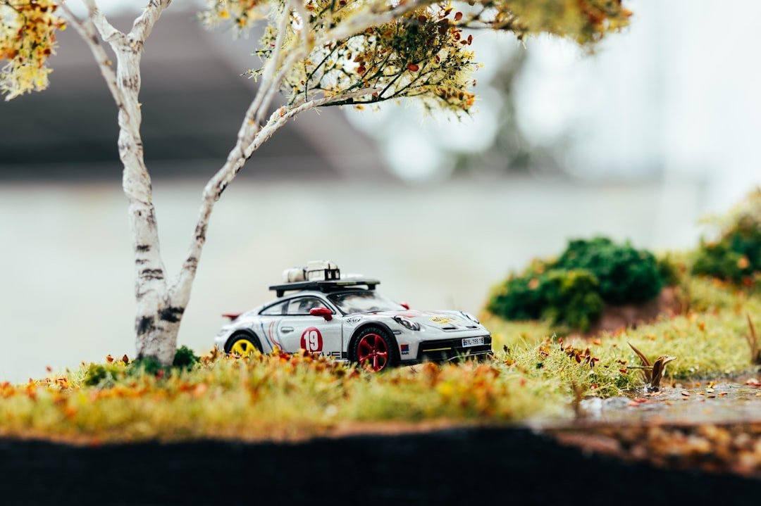 Miniature car parked under a small tree