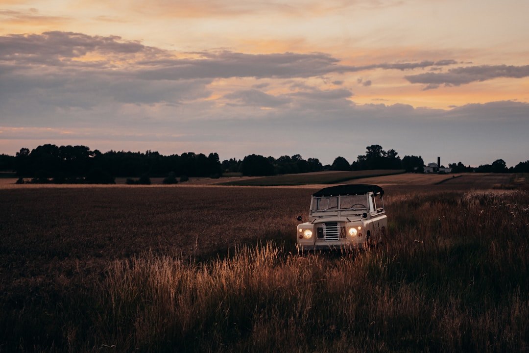 A truck parked in a field at sunset