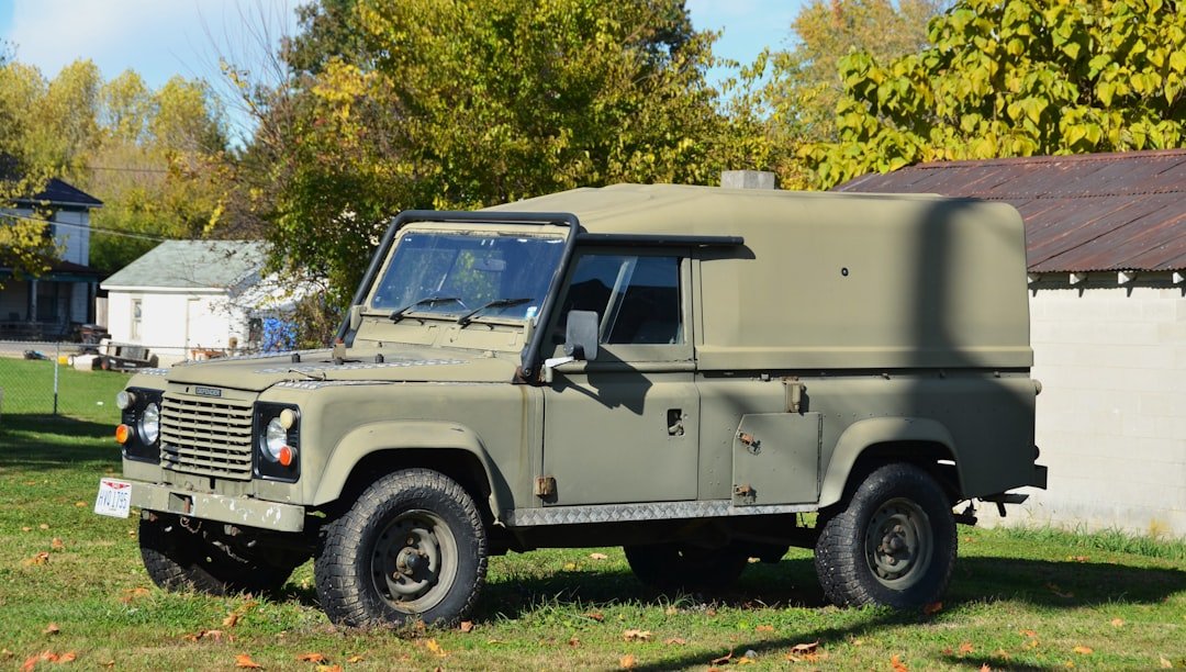Olive green utility vehicle parked on grass.