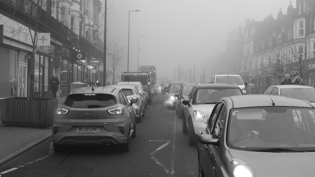 Cars stuck in traffic on a foggy street.