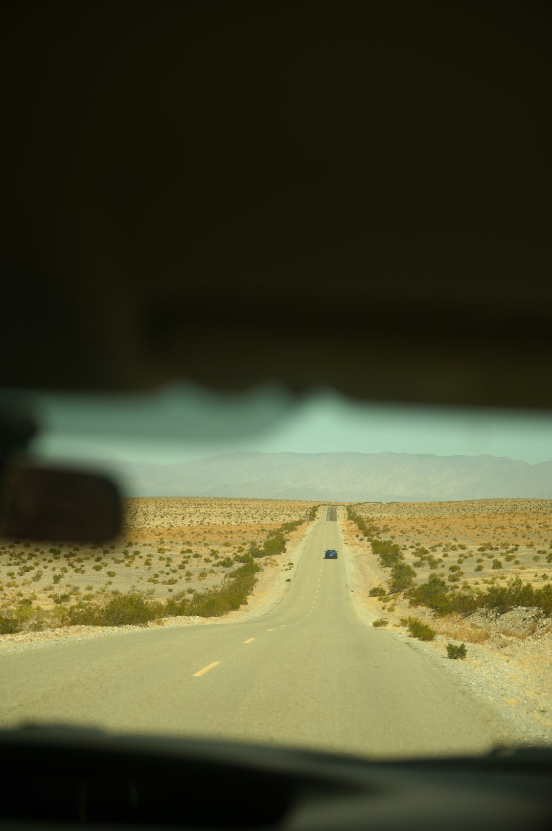 A view from inside a car of a desert road