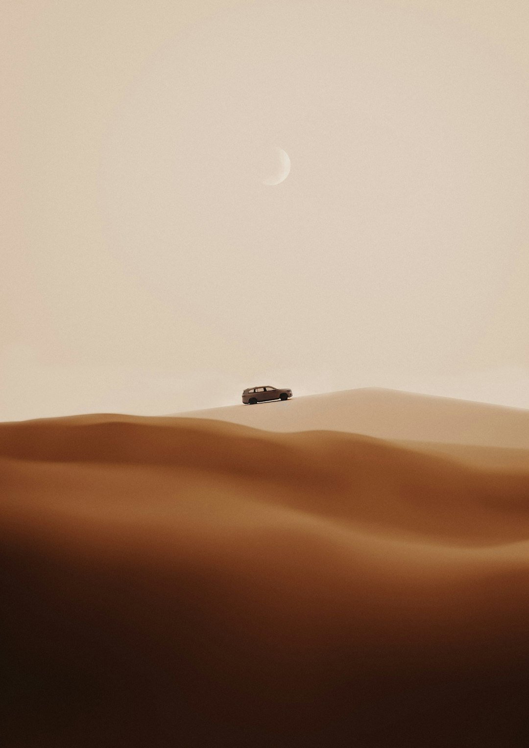 A car driving through the desert with a moon in the background