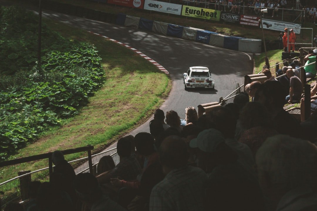 a car driving down a race track with a crowd watching