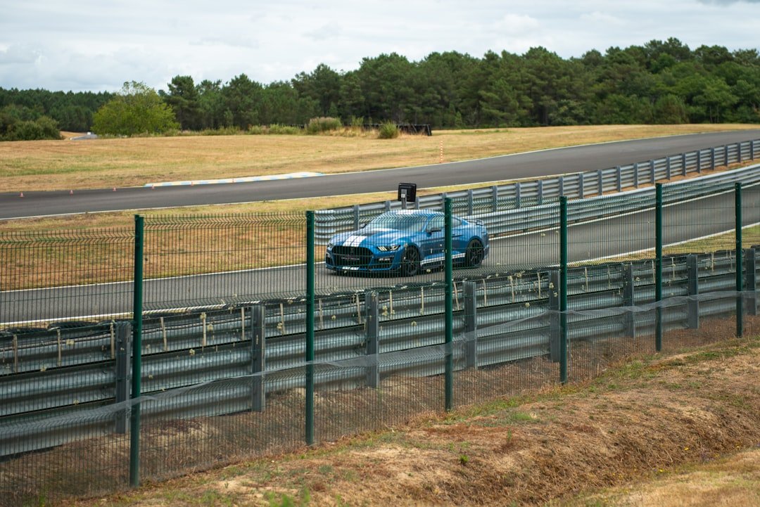 A blue race car speeds around the track.